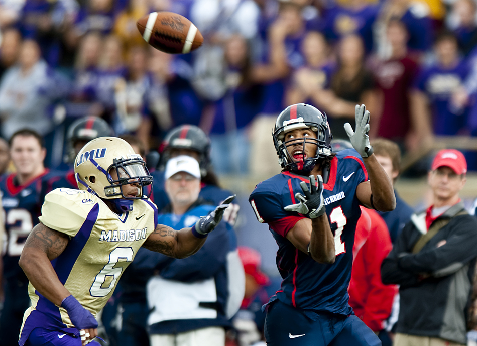 Richmond's Kevin Grayson looks back for a pass over JMU's Vidal Nelson during first quarter action at Bridgeforth Stadium in Harrisonburg on Saturday.. Richmond won the game 21-17.