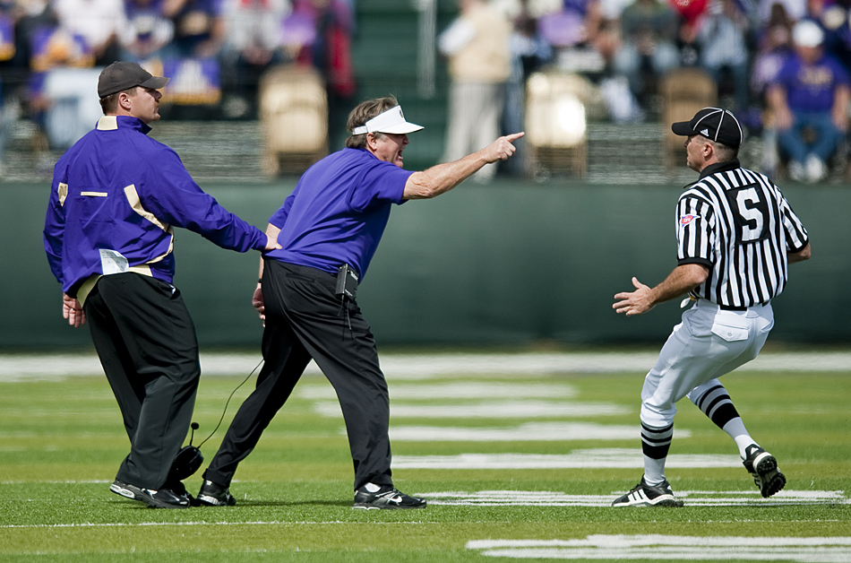 James Madison head coach Mickey Matthews is held back as he voices his displeasure over a call to one of the officials during James Madison's game against Richmond at Bridgeforth Stadium in Harrisonburg Saturday. Richmond won the game 21-17.